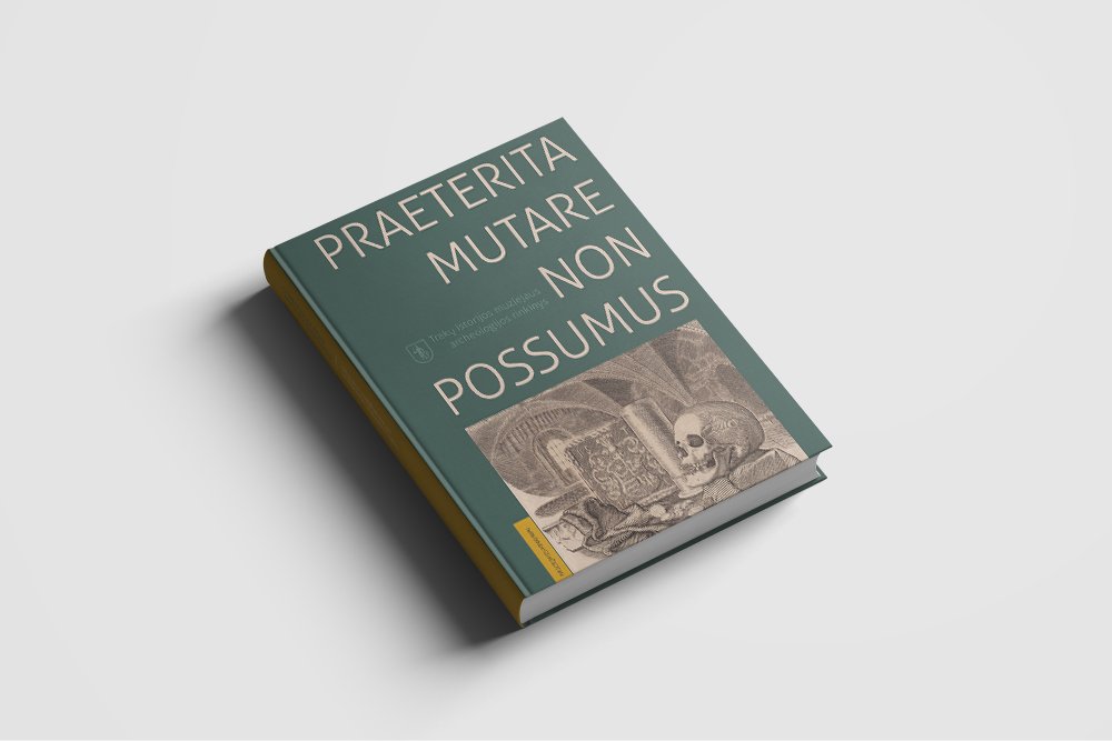 Green hardcover archaeology catalogue for Trakai History Museum, photographed at an angle on a light grey background. The cover reads “PRAETERITA MUTARE NON POSSUMUS” and features an archaeological illustration with a human skull.