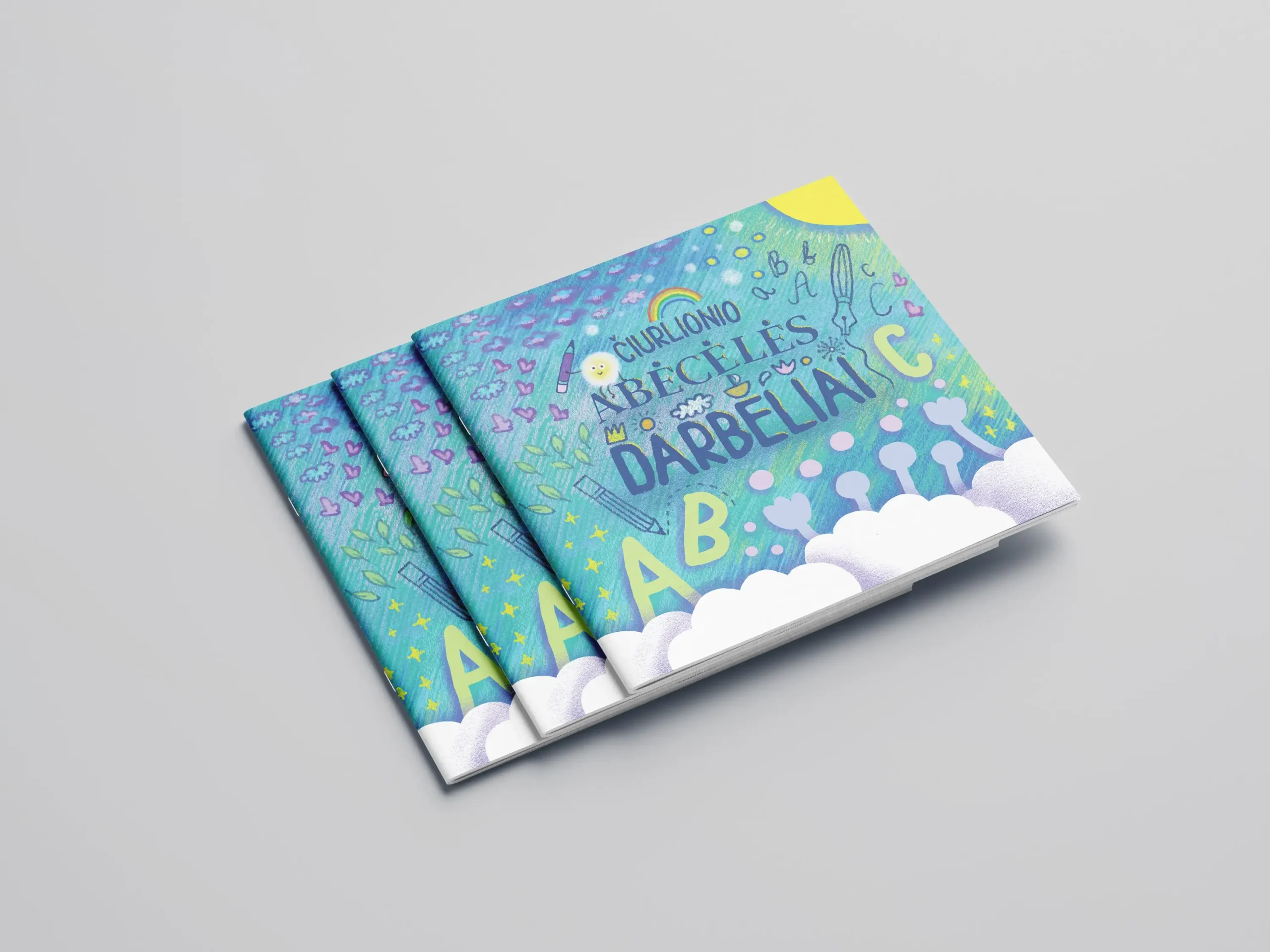 Three copies of the Čiurlionis ABC Workbook, with a colourful illustrated cover featuring letters, drawing tools, clouds and playful nature motifs.