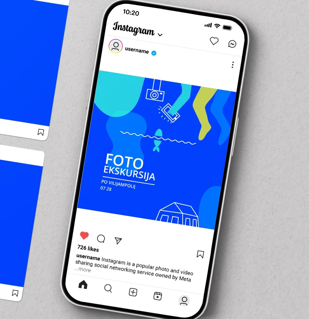 Smartphone mockup displaying a vivid blue Instagram post advertising a community photo walk. The graphic uses playful abstract shapes, a small camera, a fish, waves, and a house. Text reads: “FOTO EKSKURSIJA. PO VILIJAMPOLĘ. 07 28” (“Photo excursion around Vilijampolė, 07/28”).
