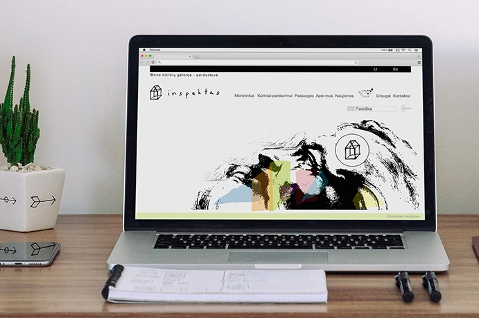 Laptop on a wooden desk displaying the Inspektas young artists’ gallery website, with a hand-drawn logo, black ink-style artwork, colorful geometric shapes, and a minimalist navigation menu. A cactus, notebook, and pens sit beside the computer.