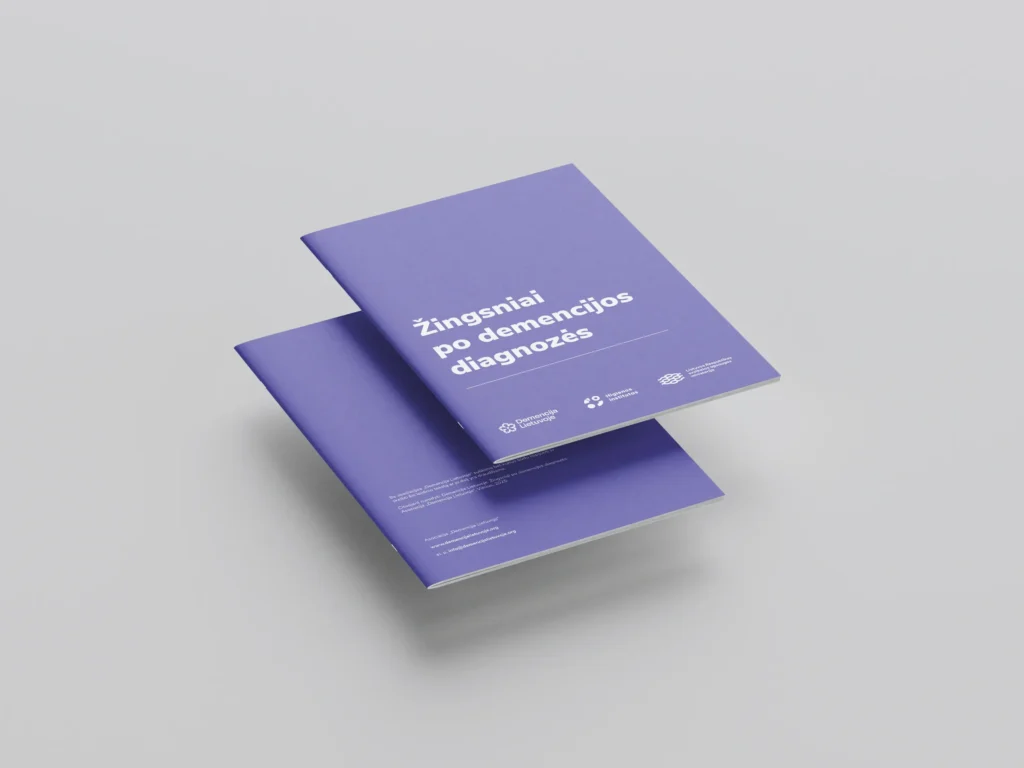 Two purple brochure covers displayed at an angle, featuring the Lithuanian title “Steps After a Dementia Diagnosis” in bold white lettering and the logos of the participating organisations.