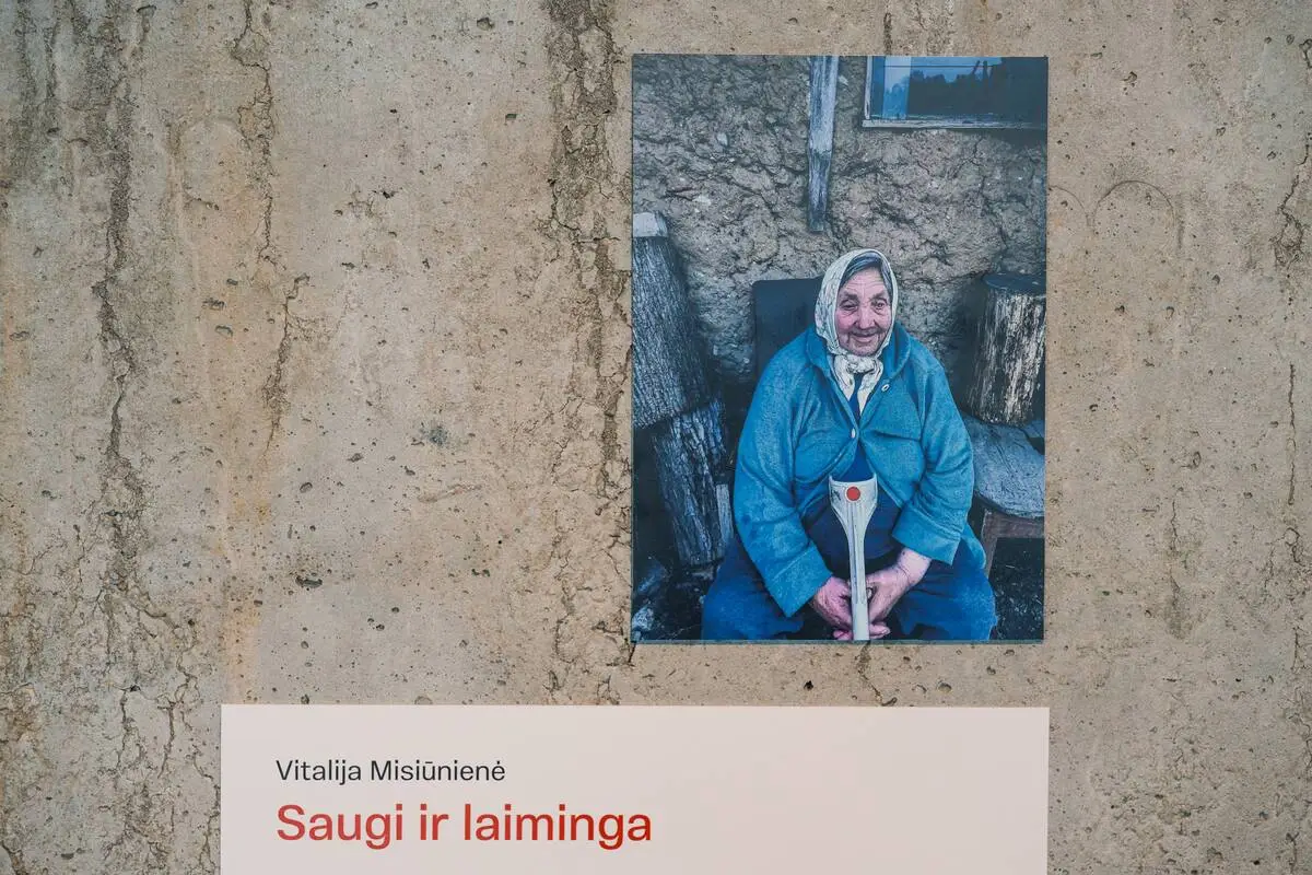 A photograph of an elderly woman in a blue coat and headscarf, displayed above a text panel titled “Safe and Happy.”