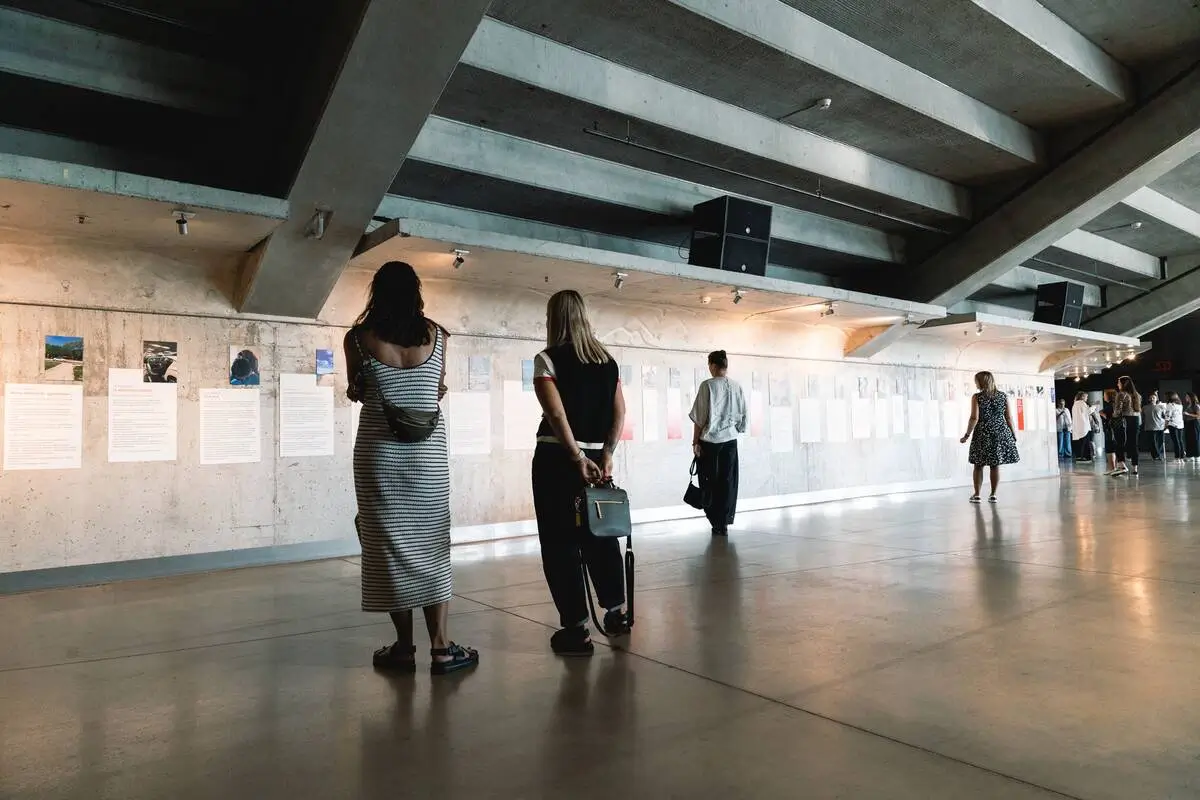 Visitors exploring the dementia awareness exhibition in the spacious concrete interior of Žalgiris Arena.