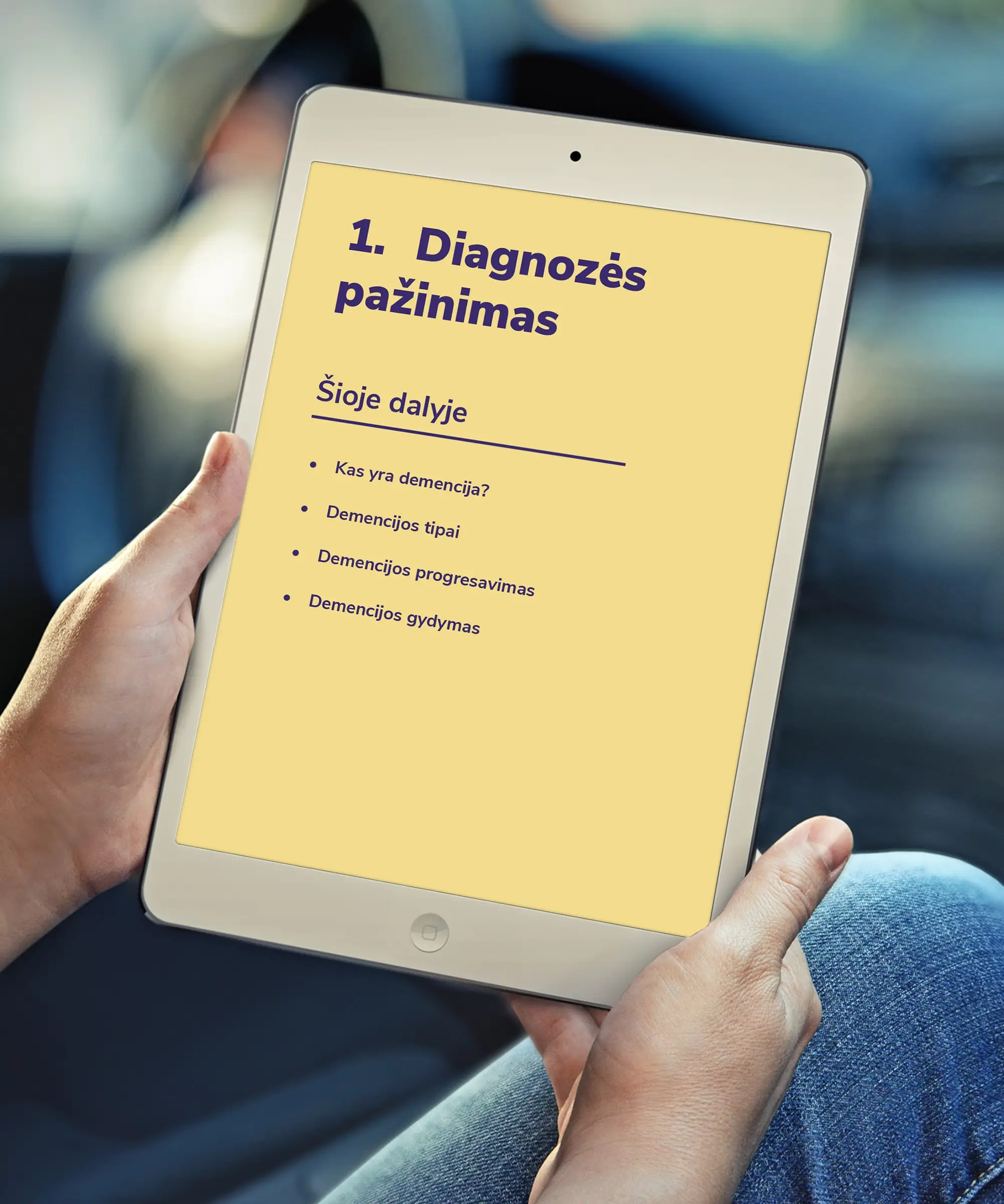 A tablet displaying a yellow chapter introduction page titled “Understanding the Diagnosis,” with purple typography and a list of topics covering dementia, its types, progression and treatment.