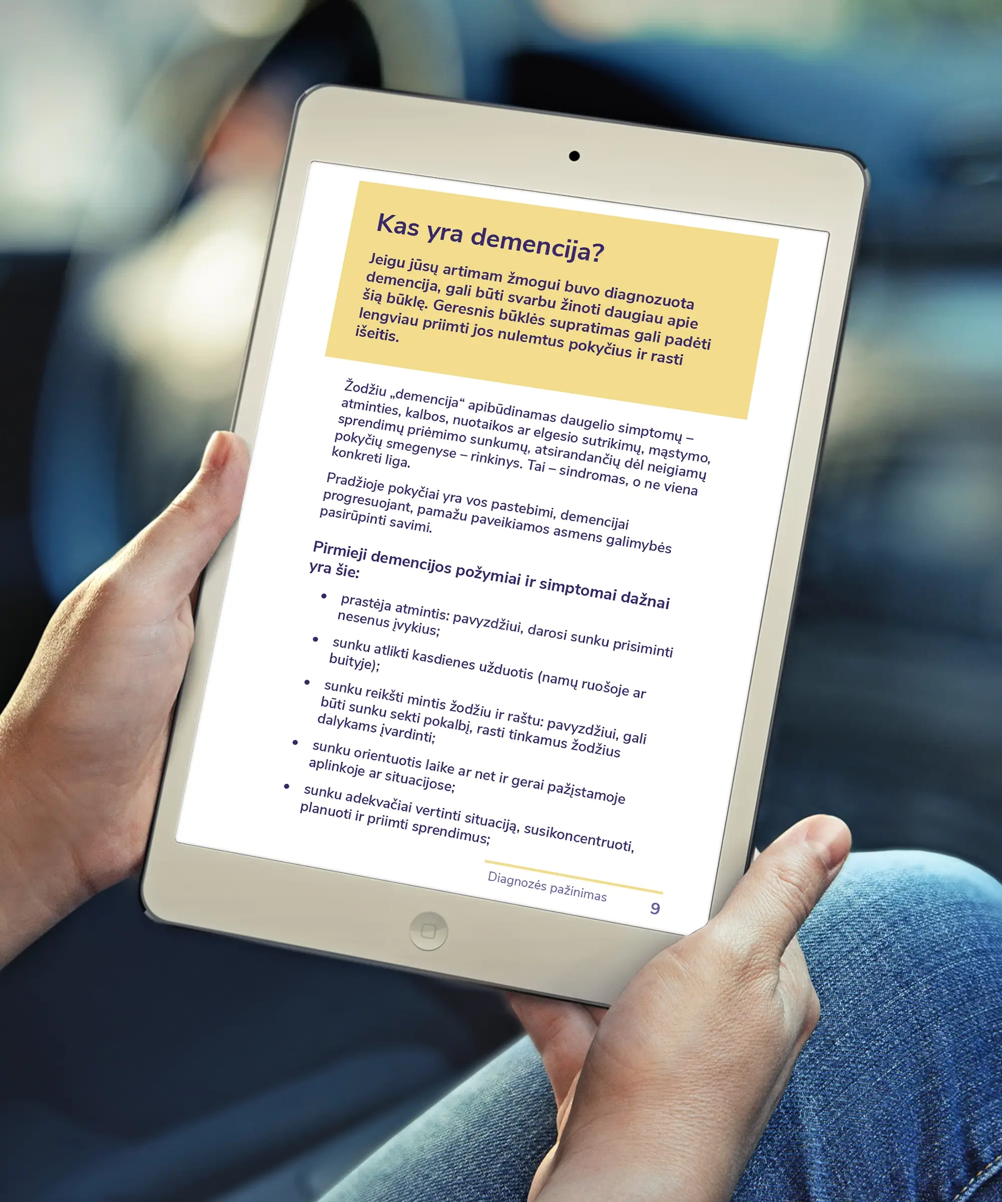 A tablet displaying a page from the accessible PDF guide explaining dementia and its early symptoms, with a yellow highlighted introduction, structured paragraphs and bullet points.
