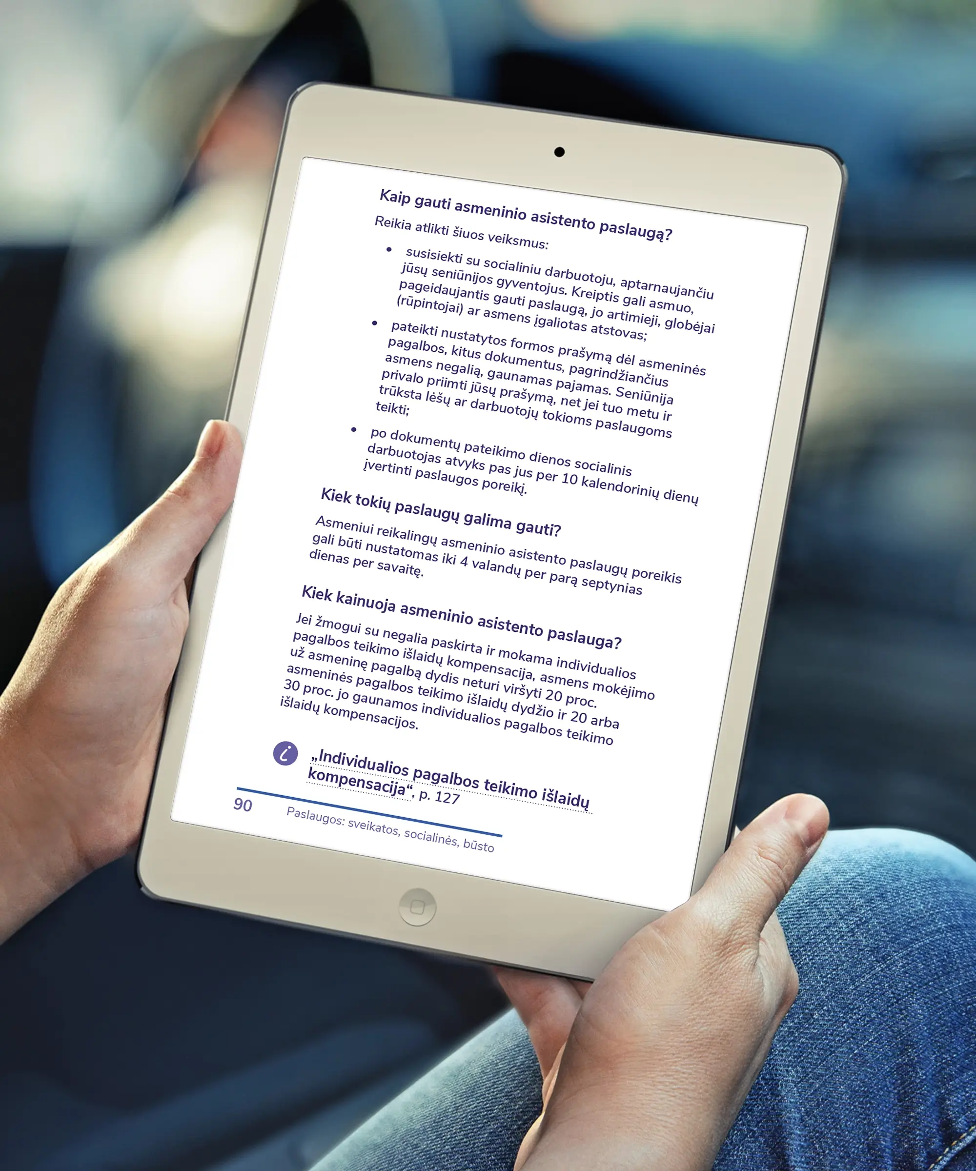 A person holding a tablet displaying a page from an accessible PDF guide, with information about applying for personal assistance services, eligibility and costs.